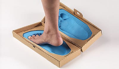 bare feet stepping into a custom orthotic